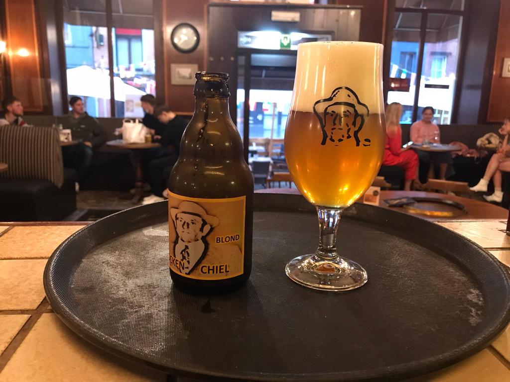 Fles en glas Stocken Chiel Blond op een dienblad in een café