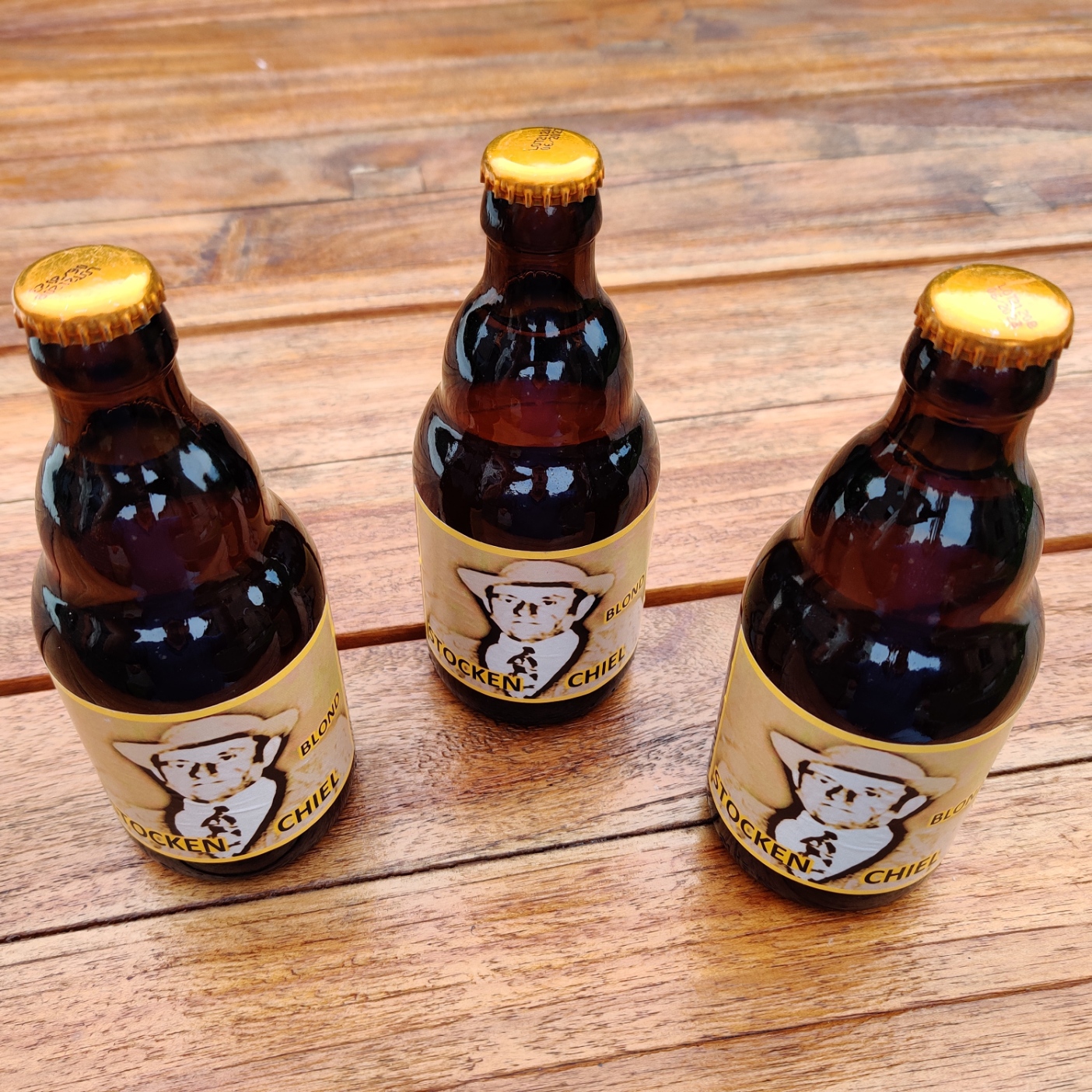 Drie flesjes Stocken Chiel Blond op een houten tafel